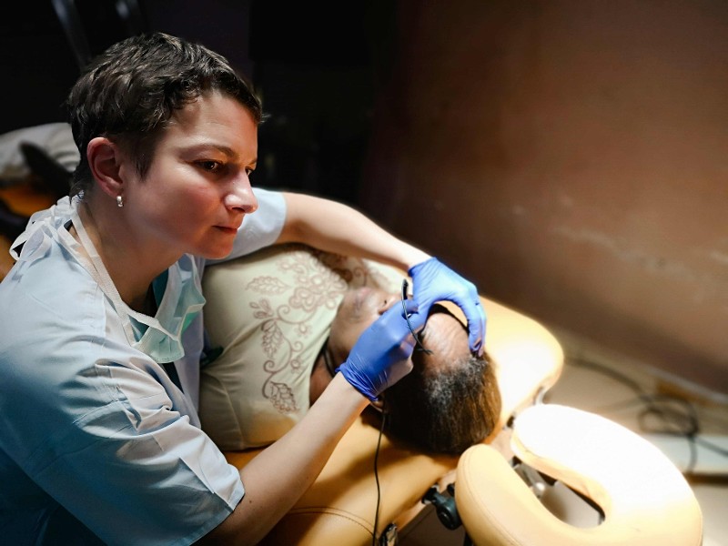 Eine &Auml;rztin untersucht einen liegenden Patienten / &copy; Privat